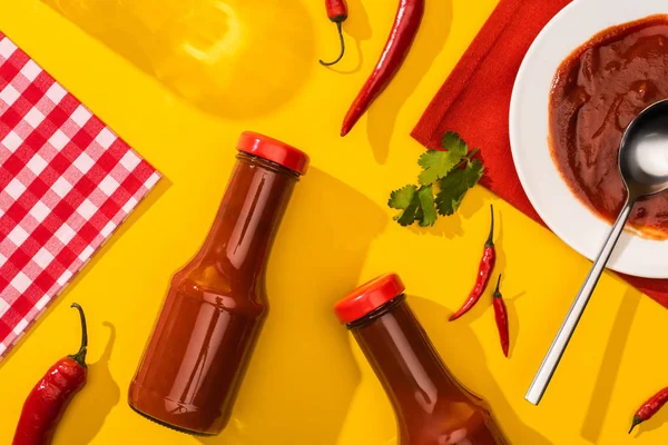 Vue du dessus de sauce tomate épicée avec piments et verdure sur fond jaune — Photo de stock