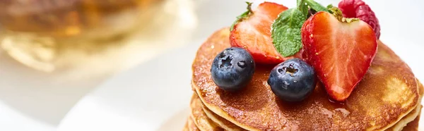 Close up view of delicious pancakes with honey, blueberries and strawberries, panoramic shot — Stock Photo