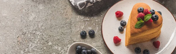 Draufsicht auf herzförmige Pfannkuchen mit Beeren auf grauer Betonoberfläche, Panoramaaufnahme — Stockfoto