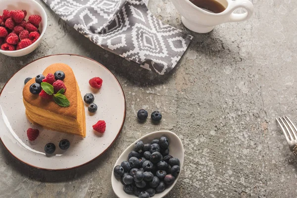 Herzförmige Pfannkuchen mit Beeren auf grauer Betonoberfläche mit Ahornsirup und Serviette — Stockfoto