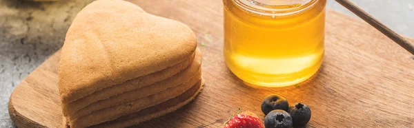 Delicious heart shaped pancakes with berries on wooden board with honey, panoramic shot — Stock Photo
