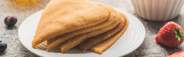 Délicieuses crêpes en forme de coeur avec des baies sur plaque sur surface en béton gris, vue panoramique — Photo de stock