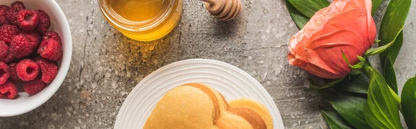 Draufsicht auf herzförmige Pfannkuchen mit Beeren, Honig und Rose auf grauer Betonoberfläche, Panoramaaufnahme — Stockfoto