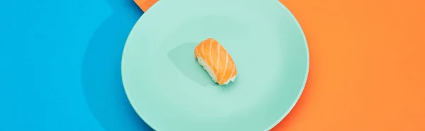 Nigiri freschi con salmone su superficie blu e arancio, colpo panoramico — Foto stock