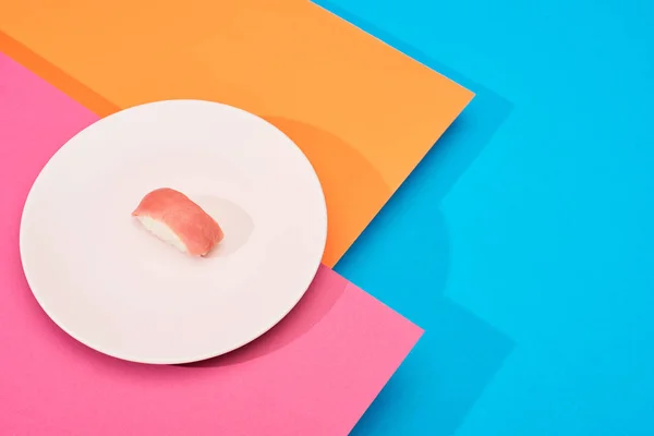 Fresh nigiri with tuna on pink, blue, orange surface — Stock Photo