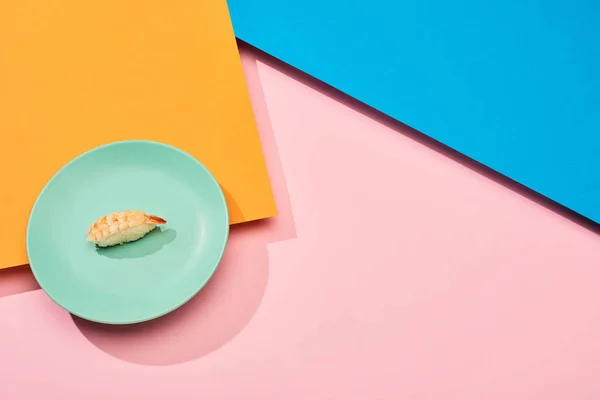 Fresh nigiri with shrimp on blue, pink, orange surface — Stock Photo