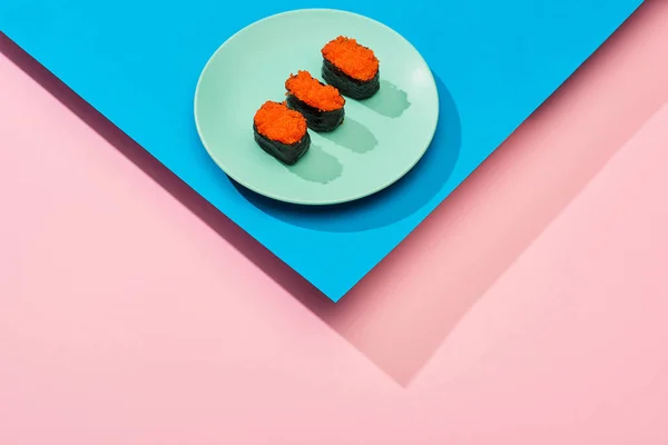 Fresh nigiri with red caviar on blue, pink background — Stock Photo