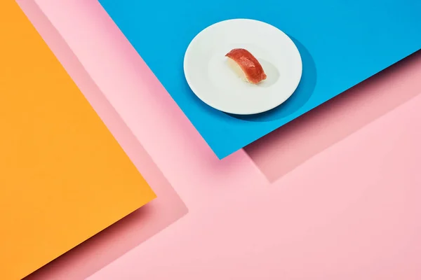 Nigiri fresco con atún sobre fondo azul, rosa, naranja - foto de stock