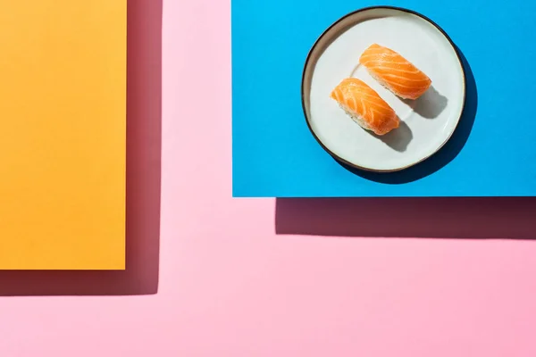 Top view of fresh nigiri with salmon on blue, pink, orange background — Stock Photo