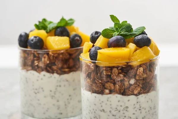 Close up view of tasty granola with canned peach, blueberries and yogurt with chia seeds — Stock Photo