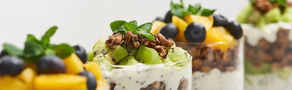 Enfoque selectivo de granola fresca con kiwi y durazno enlatado con arándanos aislados en blanco, plano panorámico - foto de stock