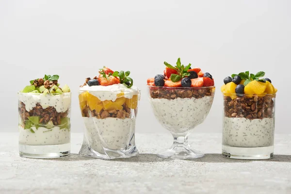 Deliciosa granola en vasos con frutas y bayas aisladas en blanco - foto de stock