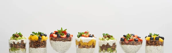 Délicieux granola dans des verres avec des fruits et des baies isolés sur blanc, vue panoramique — Photo de stock