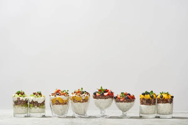 Deliciosa granola en vasos con frutas y bayas aisladas en blanco - foto de stock