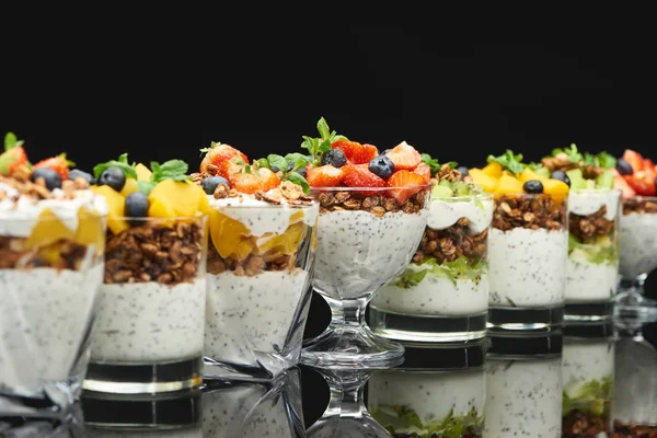 Foco seletivo de granola fresca com frutas frescas e bagas isoladas em preto — Fotografia de Stock