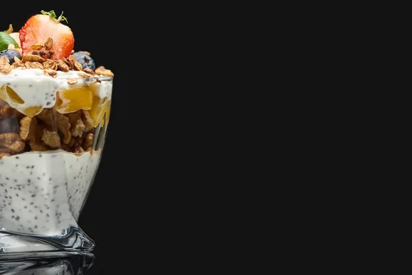 Свежий мюсли с консервированным персиком, ягодами, грецкими орехами и семенами чиа, изолированными на черном — стоковое фото