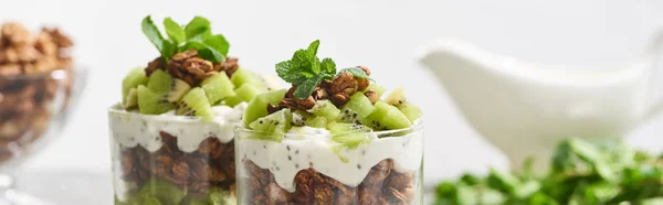 Selective focus of fresh granola with kiwi and yogurt isolated on grey — Stock Photo