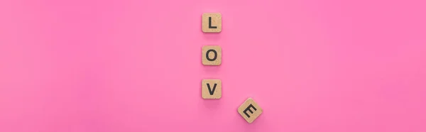 Vista superior de letras de amor em cubos de madeira isolados em fundo rosa, tiro panorâmico — Fotografia de Stock