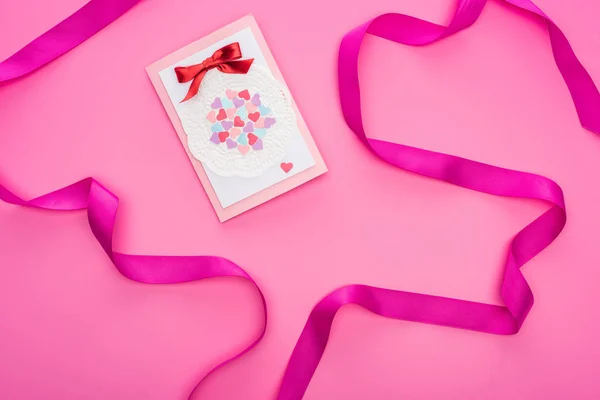 Vista dall'alto del biglietto di auguri di San Valentino con nastro isolato su rosa — Foto stock