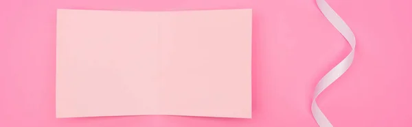 Вид зверху порожня паперова картка зі стрічкою ізольована на рожевому, панорамному знімку — стокове фото