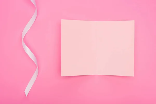 Top view of empty paper card with ribbon isolated on pink — Stock Photo