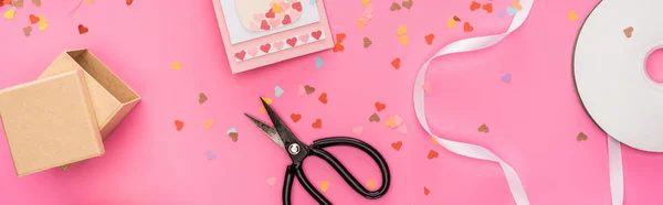 Top view of valentines confetti, empty compact disk, gift box, greeting card, scissors on pink background, panoramic shot — Stock Photo