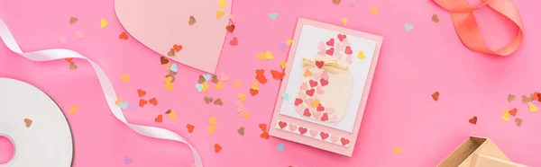 Top view of valentines confetti, empty compact disk, gift box, greeting card on pink background, panoramic shot — Stock Photo