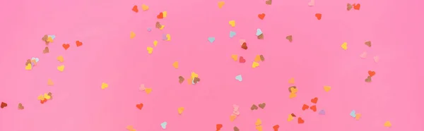 Vista superior de los confeti de San Valentín esparcidos sobre fondo rosa, plano panorámico - foto de stock