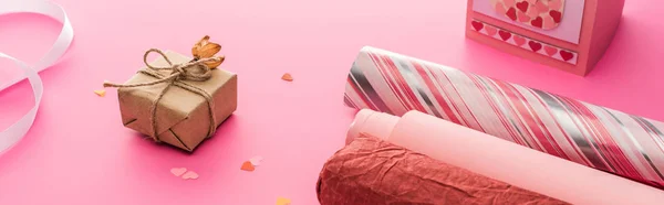 Confettis de Saint-Valentin, papier d'emballage, boîte cadeau sur fond rose, panoramique — Photo de stock