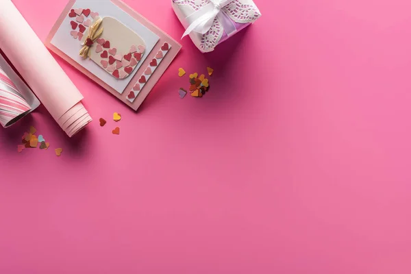 Vista dall'alto della decorazione di San Valentino con biglietto di auguri e presente su sfondo rosa — Foto stock