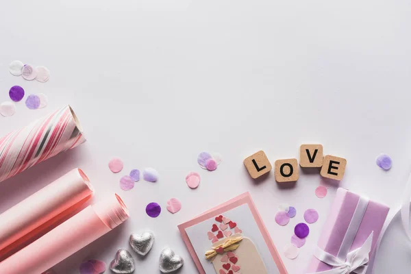 Top view of valentines decoration, gifts and cubes with love lettering on white background — Stock Photo