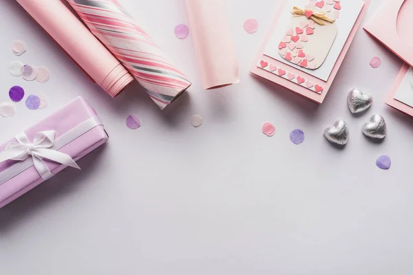 Vista superior da decoração dos namorados, presentes, corações e papel de embrulho no fundo branco — Fotografia de Stock