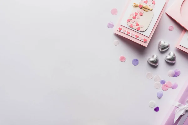 Vue du dessus de la décoration des valentines, carte de voeux, coeurs, confettis sur fond blanc — Photo de stock