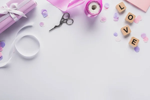 Vista dall'alto della decorazione di San Valentino, regalo, forniture a mano e lettere d'amore su cubi su sfondo bianco — Foto stock