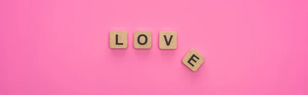 Top view of love lettering on wooden cubes on pink background, panoramic shot — Stock Photo