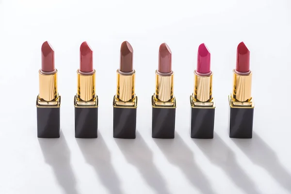 Assorted lipsticks in luxury tubes in line on white background — Stock Photo