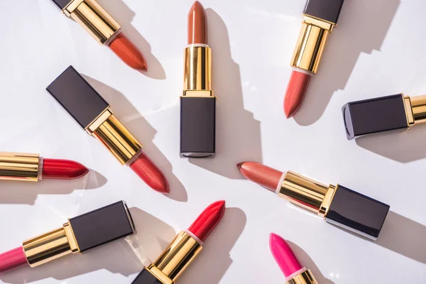 Top view of assorted lipsticks in luxury tubes on white background — Stock Photo