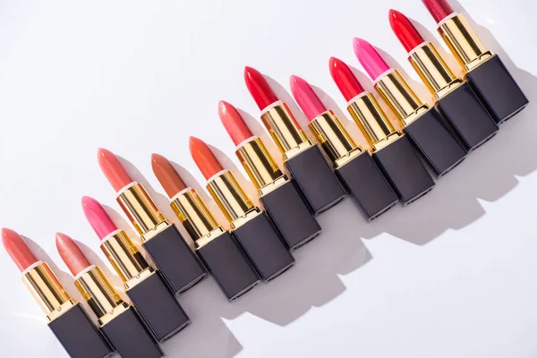 Top view of assorted lipsticks in luxury tubes on white background — Stock Photo