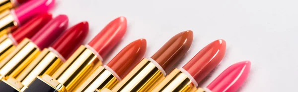 Close up view of assorted lipsticks in luxury tubes on white background, panoramic shot — Stock Photo