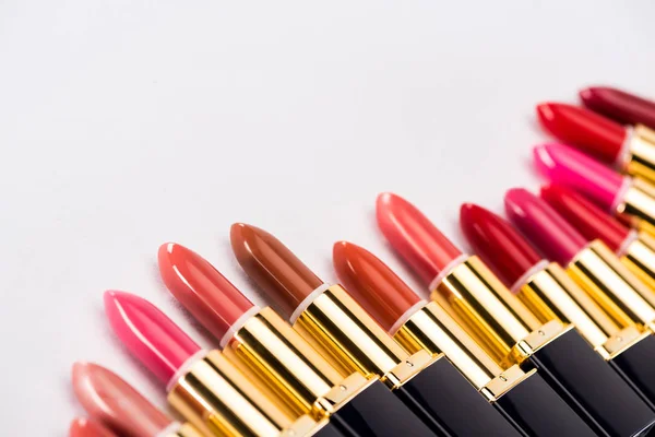 Close up view of assorted lipsticks in luxury tubes on white background — Stock Photo