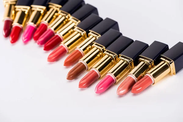 Selektiver Fokus verschiedener Lippenstifte in Luxusröhren auf weißem Hintergrund — Stockfoto