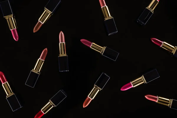 Vista superior de lápices labiales surtidos en tubos de lujo aislados en negro - foto de stock