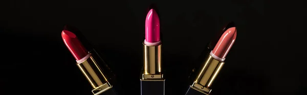 Top view of assorted lipsticks in luxury tubes isolated on black, panoramic shot — Stock Photo