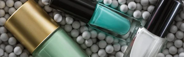 Vue du dessus du vernis à ongles assorti en bouteilles en perles décoratives grises, panoramique — Photo de stock