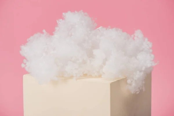 White fluffy cloud made of cotton wool on cube isolated on pink background — Stock Photo