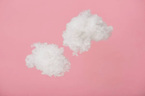 Nubes esponjosas blancas hechas de algodón aislado en rosa - foto de stock