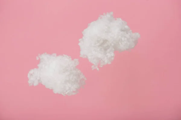 Nuvens fofas brancas feitas de lã de algodão isolado em rosa — Fotografia de Stock