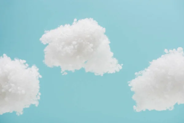 Nubes esponjosas blancas hechas de algodón aislado sobre fondo azul - foto de stock