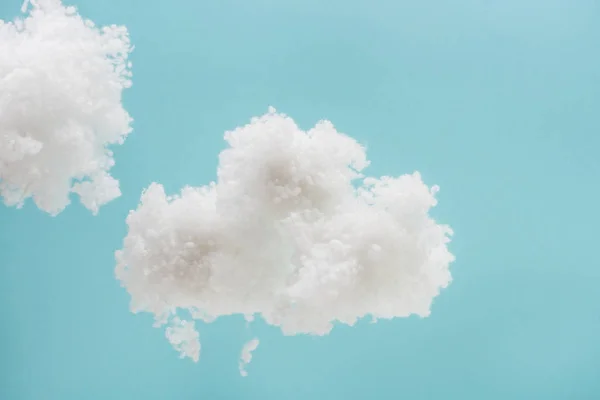 Weiße flauschige Wolken aus Watte isoliert auf blauem Hintergrund — Stockfoto