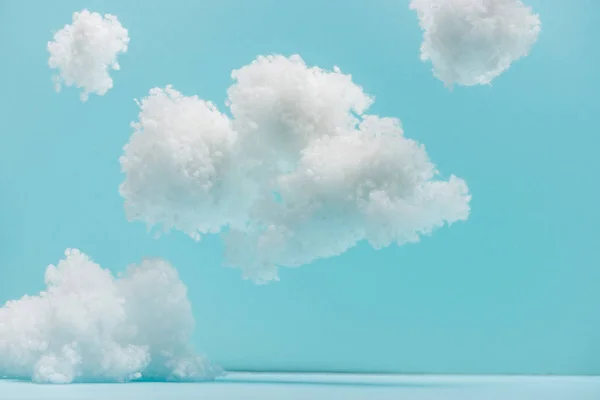 Nuvens fofas brancas feitas de lã de algodão isolado em azul — Fotografia de Stock